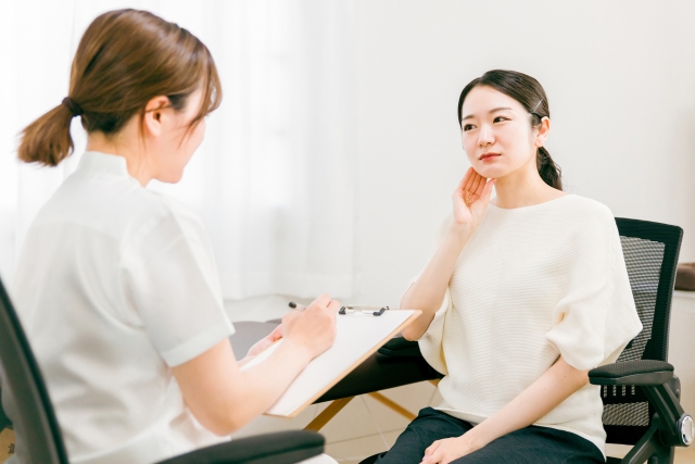 痛みで悩む患者を診察する女性医師